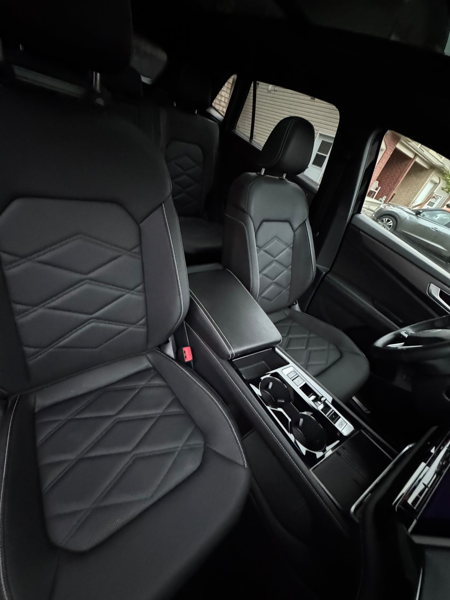 Freshly cleaned black leather seats and center console after commercial detailing