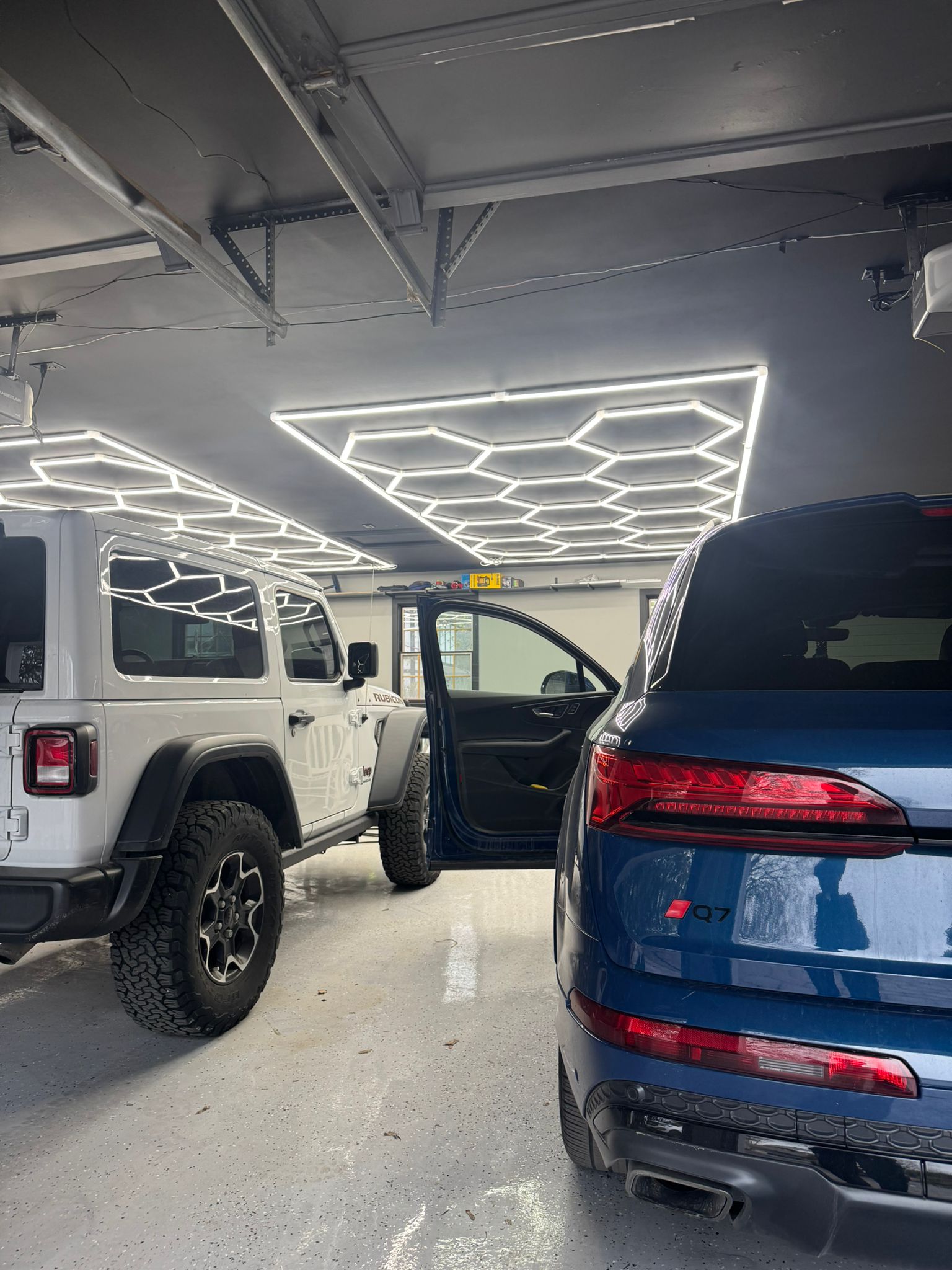 Pro Nano Solutions fleet vehicles detailed in a premium showroom with hexagon lighting