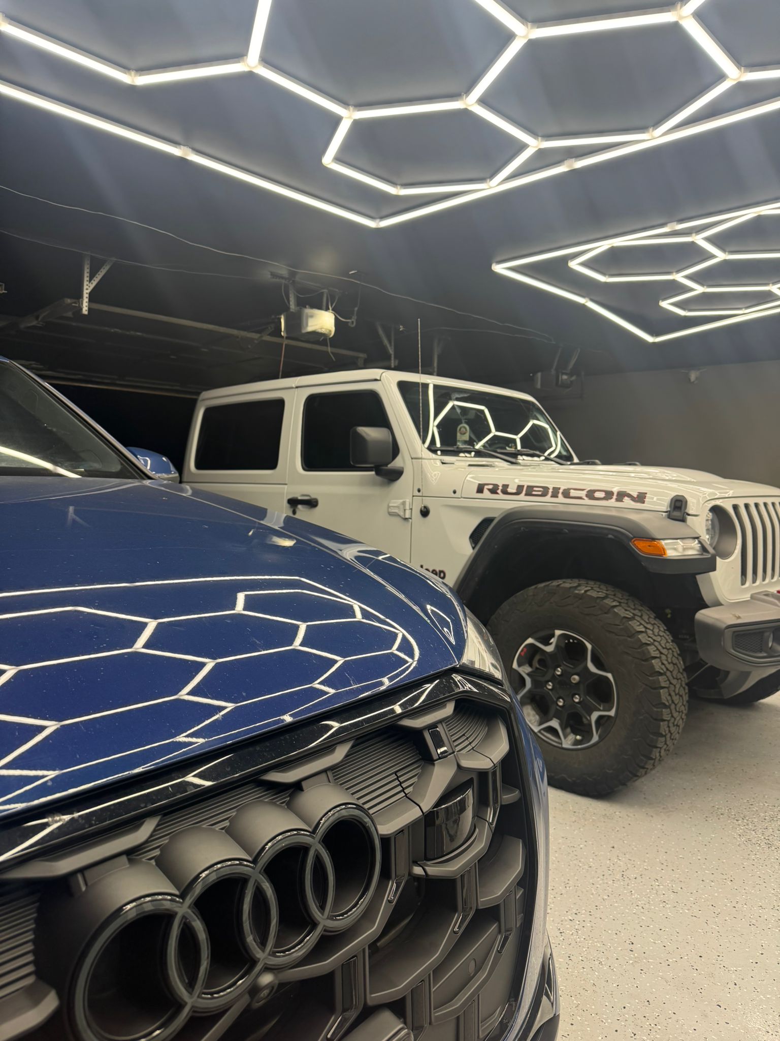 Clean Cabin detailing showroom with fleet vehicles under premium hexagon lighting